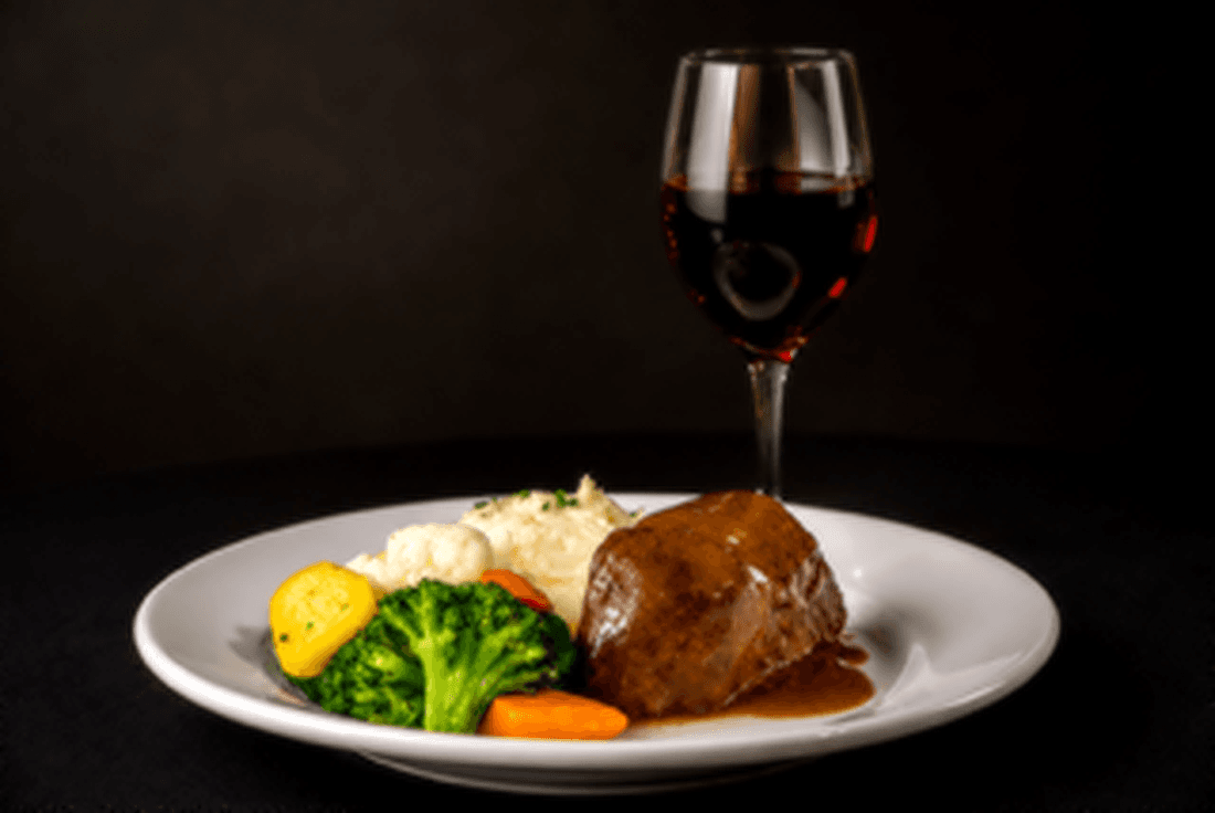 Short rib pot roast with boursin mashed potatoes, seasonal vegetables, cabernet gravy and a glass of red wine